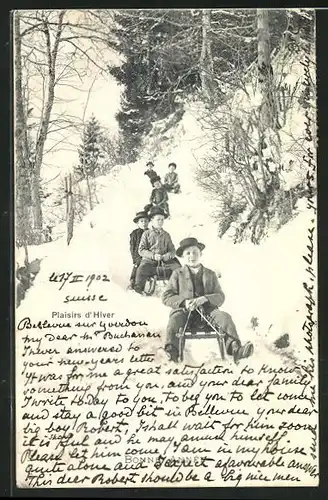 AK Jungs fahren auf ihren Schlitten im Winter einen Hang hinunter