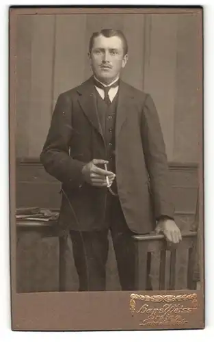 Fotografie Hans Weiss, Erding, Portrait junger Herr in Anzug mit Zigarette