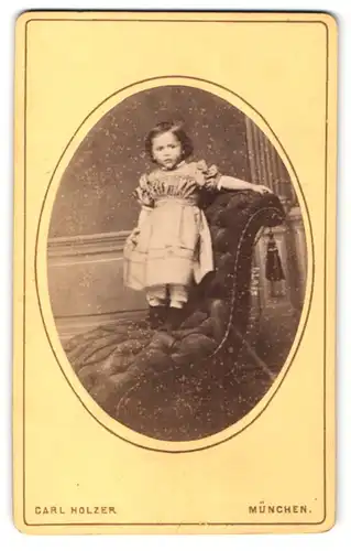 Fotografie Carl Holzer, München, Portrait kleines Mädchen im hübschen Kleid auf Sessel stehend
