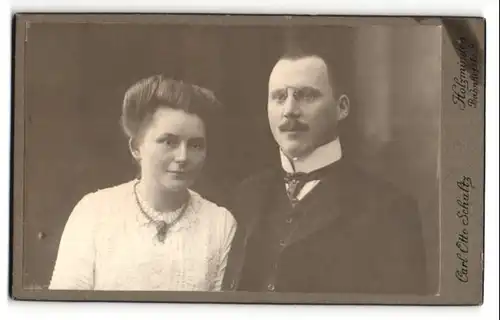 Fotografie Carl Otto Schultz, Holzminden, Mann im Anzug mit Brille und Schnurrbart und Frau im Kleid mit Halskette