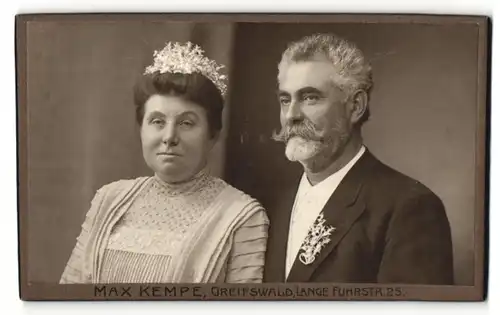 Fotografie Max Kempe, Greifswald, Frau im Kleid mit Krone im Haar und Mann im Anzug mit Zweig am Jacket