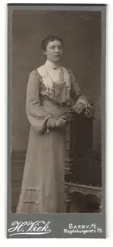Fotografie H. Viek, Barby a. E., Portrait junge Dame im Kleid an einem Stuhl