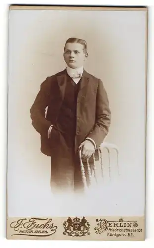 Fotografie Fuchs, Berlin, Portrait Junge im Anzug an einem Stuhl