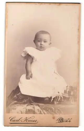 Fotografie Carl Kruse, Burg, Portrait bezauberndes Baby im weissen Taufkleidchen