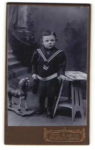 Fotografie Otto Martin, Dresden-Löbtau, Portrait bezauberndes Kleinkind mit Spielzeugpferd