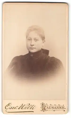 Fotografie Osw. Welti, Lausanne, Portrait charmante junge Frau mit blondem Haar in dunkler Bluse