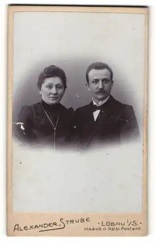 Fotografie Alexander Strube, Löbau i. Sa., Portrait elegant gekleidetes Paar mit charmanten Blicken