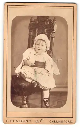 Fotografie F. Spalding, Chelmsford, Portrait lachendes kleines Mädchen im wunderschönen Kleid mit Rüschenmütze