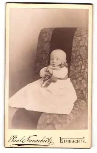 Fotografie Paul Nauschütz, Limbach i/S, Portrait Säugling in Kleid auf Sitzmöbel