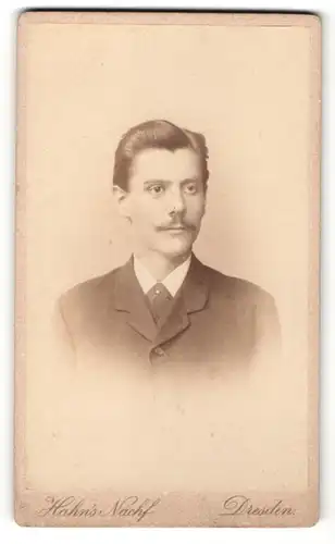 Fotografie Hahn`s Nachf., Dresden, Portrait charmanter Herr im Anzug mit Krawatte und Zwirbelbart