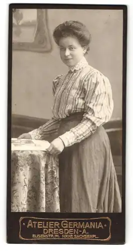 Fotografie Atelier Germania, Dresden-A., Portrait junge Dame in gestreifter Bluse mit Buch an Tisch gelehnt