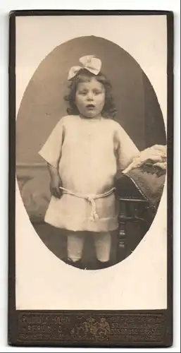 Fotografie Rudolf Hahn, Berlin-O, Portrait kleines Mädchen im weissen Kleid mit Haarschleife