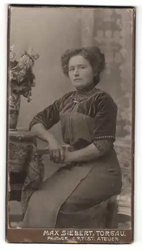 Fotografie Max Siebert, Torgau, Portrait bürgerliche Dame in modischer Kleidung auf Bank sitzend