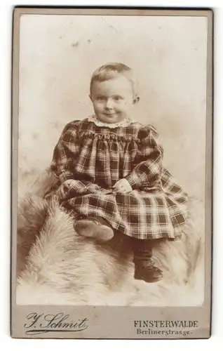 Fotografie J. Schmit, Finsterwalde, Portrait Kleinkind in kariertem Kleid