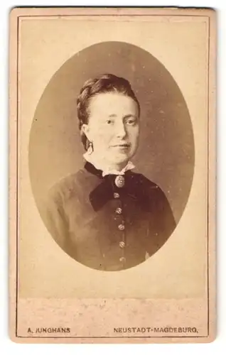 Fotografie A. Junghans, Magdeburg-Neustadt, Portrait bürgerliche Dame mit Flechtfrisur und Kragenbrosche