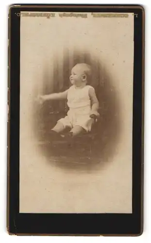 Fotografie unbekannter Fotograf und Ort, Portrait Säugling auf Sitzmöbel