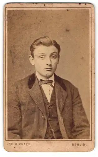 Fotografie Joh. Richter, Berlin, Portrait junger Mann mit zurückgekämmtem Haar in Anzug