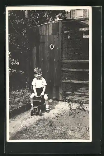 Foto-AK Kleiner Junge auf einem Spielzeugauto