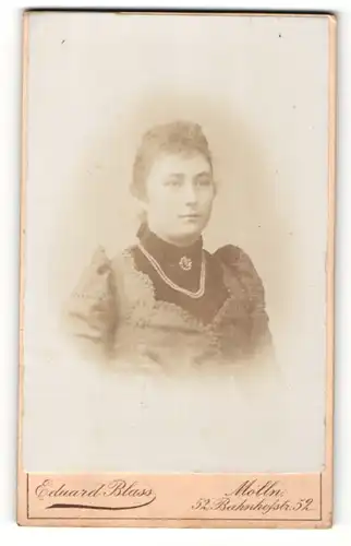 Fotografie Eduard Blass, Mölln, Portrait bezaubernde junge Frau mit Perlenhalskette und Brosche am Kragen