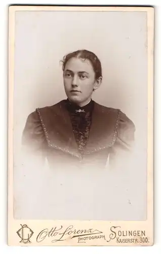 Fotografie Otto Lorenz, Solingen, Frau in dunklem Kostüm mit Rüscheneinsatz und Brosche