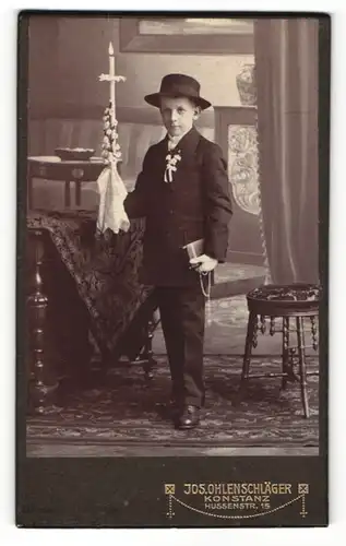 Fotografie Jos. Ohlenschläger, Konstanz, Portrait Knabe in festlicher Kleidung mit Hut und Kerze