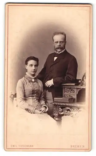 Fotografie Emil Tiedemann, Bremen, Portrait bürgerliches Paar in hübscher Kleidung