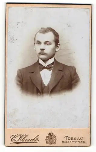 Fotografie C. Klaucke, Torgau, Portrait junger Herr im Anzug mit Fliege