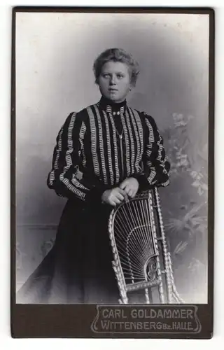Fotografie Carl Goldammer, Wittenberg, Portrait Dame in gestreifter Bluse an einem Stuhl