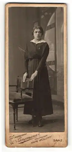 Fotografie W. Langmann, Saaz, Portrait Dame im schwarzen Kleid an einem Stuhl