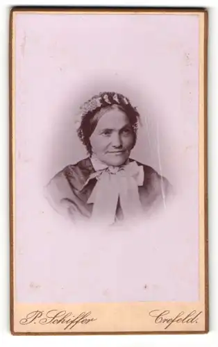 Fotografie P. Schiffer, Crefeld, Alte Frau mit Häubchen im Schleifenkleid