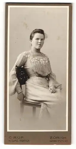 Fotografie C. Ruf, Zürich, Portrait sitzende junge Dame in hübscher Kleidung