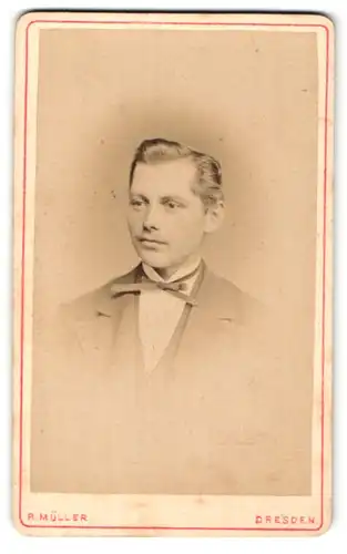 Fotografie R. Müller, Dresden, Herr mit pomadisertem Haar in feinem Anzug mit Schleife