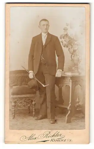 Fotografie Alex. Richter, Kamenz i / S., Portrait charmanter Herr im Anzug mit Krawatte und Stock