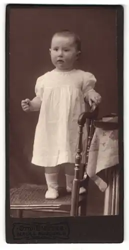 Fotografie Otto Hoepfke, Berlin, Portrait Kleinkind im Kleidchen auf einem Stuhl