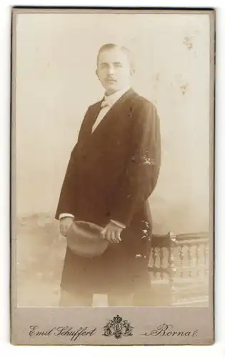 Fotografie Ernst Schuffert, Borna, junger Mann in Mantel mit Mütze in der Hand