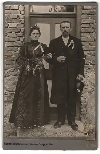 Fotografie Eugen Glasbrenner, Wasserburg / Inn, Portrait elegant gekleidetes Paar mit Blumenstrauss und Ansteckblume