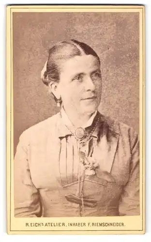 Fotografie R. Eich, Dresden, Portrait bürgerlich gekleidete Dame mit Kragenbrosche und Ansteckblume