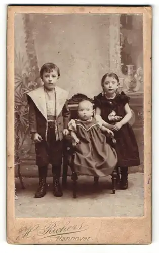 Fotografie H. Richers, Hannover, Portrait modisch gekleidetes Kindertrio