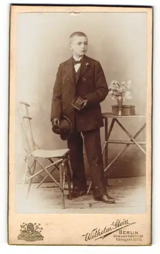 Fotografie Wilhelm Stein, Berlin, Portrait niedlicher Bube mit Hut im Anzug