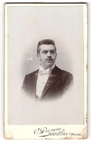 Fotografie O. Damm, Marburg i / Hessen, Portrait bürgerlicher Herr im Anzug mit Fliege und Schnauzbart
