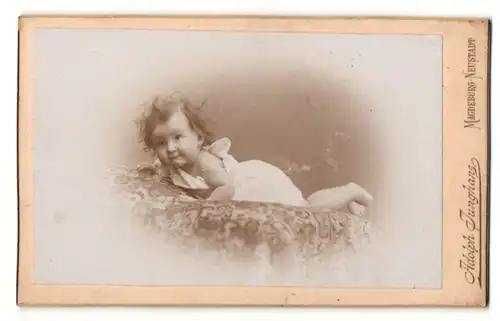 Fotografie Adolph Junghans, Magdeburg-Neustadt, Baby liegt auf einem Kissen