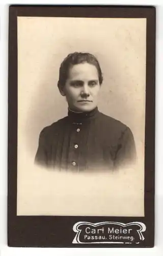 Fotografie Carl Meier, Passau, junge Frau im schwarzen Kleid, mit hochgestecktem Haar blickt rechts an der Kamera vorbei