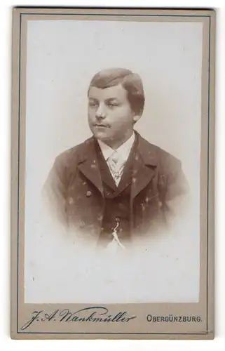 Fotografie J. A. Wankmüller, Obergünzburg, fülliger junger Mann mit Seitenscheitel in Anzug und mit Uhrenkette