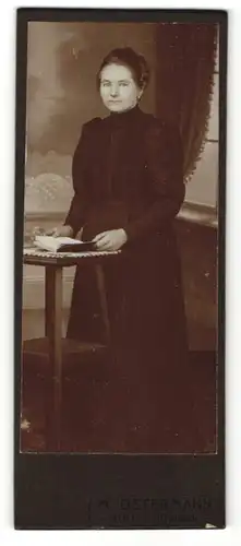 Fotografie M. Ostermann, Adorf i / Waldeck, Portrait bürgerlich gekleidete Dame mit Buch an Tisch gelehnt
