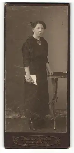 Fotografie Atelier Apollo, Dresden, Frau in schwarzer Kleidung mit ernster Miene