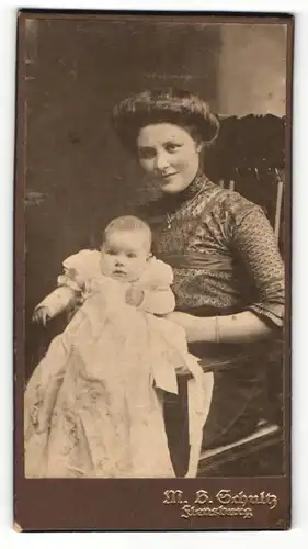 Fotografie M. B. Schultz, Flensburg, Portrait stolze Mutter in hübscher Bluse mit Baby auf dem Schoss