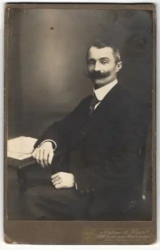 Fotografie A. Kiesel, Wilhelmshaven-Rüstringen, Portrait bürgerlich gekleideter Herr mit Schnauzbart am Tisch sitzend