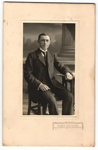 Fotografie Alwin Dietrich, Glauchau, Portrait elegant gekleideter Herr mit Zeitung am Tisch sitzend