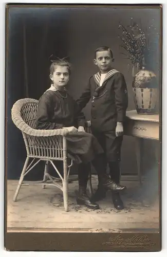Fotografie Aug. Müller, Berlin-Spandau, Portrait Mädchen mit Haarschleife und jüngerer Bruder im Matrosenhemd