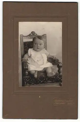 Fotografie Ronneberger & Sohn, Falkenstein i. V., Baby auf Sessel sitzend